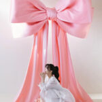 リボンの前で座る新婦様
