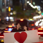 夜の道路でハートを持った新郎新婦