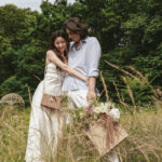 野原でピクニックをする新郎新婦